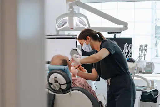 Dentist treating a patient in the dental chair during a restorative procedure at White Clinic in Lisbon